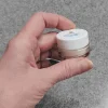 corum-mattifying-setting-powder-hand-holding-sample-jar