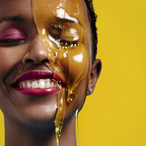 Beautiful smiling black woman with plant oils for skin running down her face