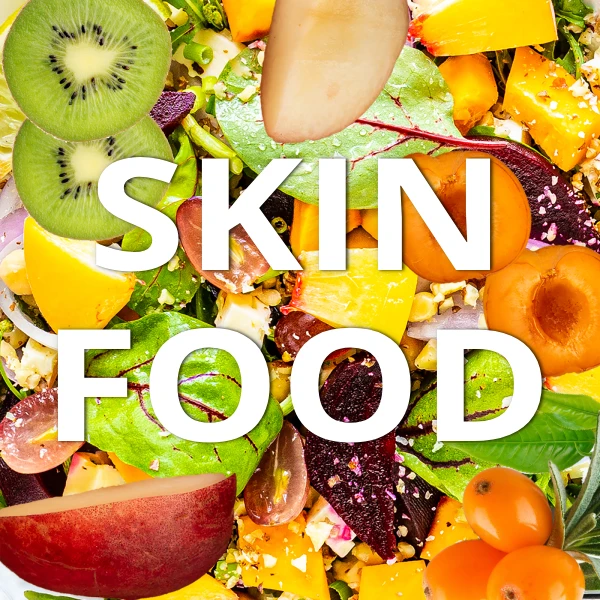 A vibrant overhead layout of skin-boosting foods including salmon, broccoli, sweet potatoes, blueberries, and almonds with the text Skin Food.