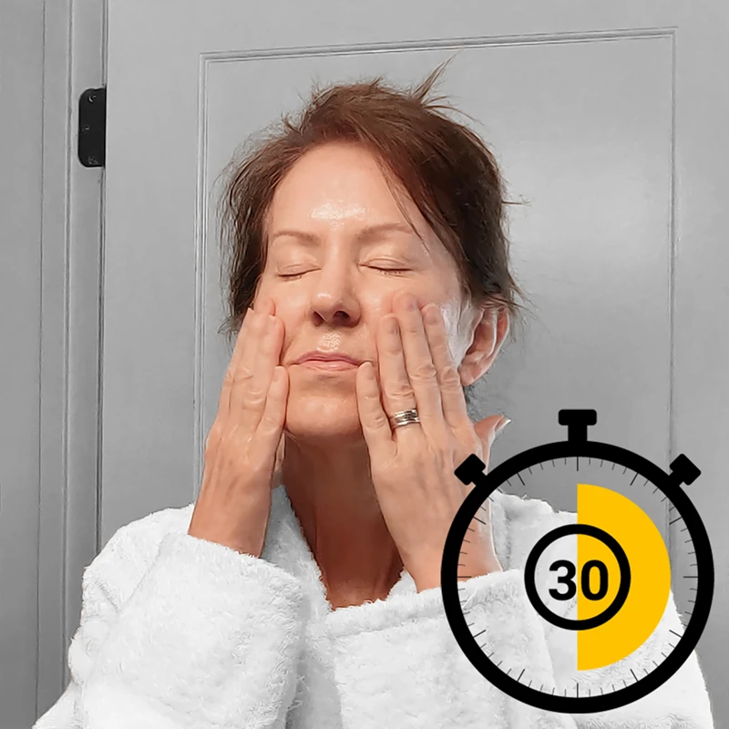 Middle aged woman massaging her face with cleansing oil
