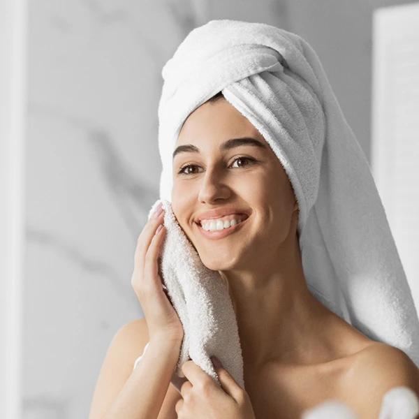 happy-woman-in-bathrobe-looking-in-a-mirror-repair-skin-barrier-damage