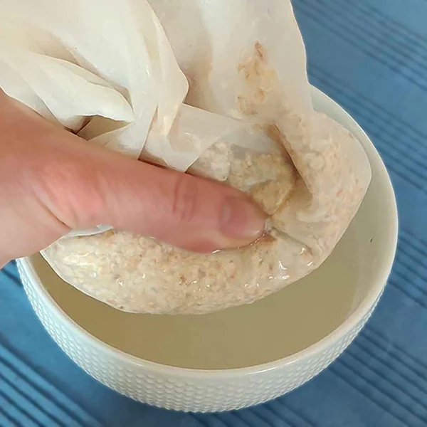 Squeezing a muslin bag of colloidal oatmeal for skin paste for fast relief from itchy skin